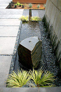The stone was drilled and centered on the steel basin, one of the few symmetrical alignments on the job. The rill makes a right hand turn as it stretches towards the spillway on the other side of the steel wall.