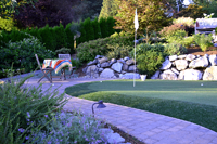 A putting green with sitting area by Nyce Gardens