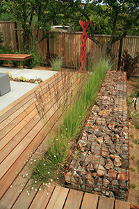The two tiered rear yard space was separated using a custom gabion wall. Plantings and decking direct the viewer to the ‘DNA’ sculpture at the end of the deck.